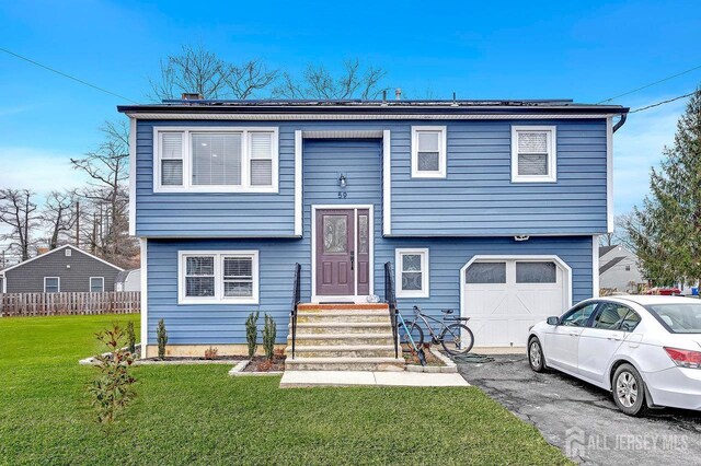 split foyer home featuring a front yard and a garage