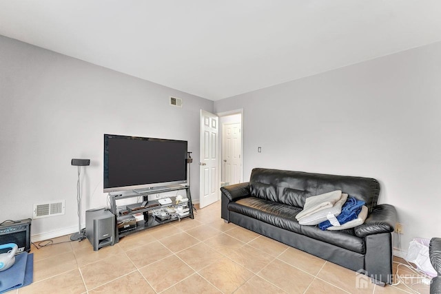 living area featuring light tile patterned floors, visible vents, and baseboards