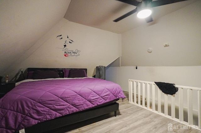 bedroom with ceiling fan, vaulted ceiling, and wood finished floors