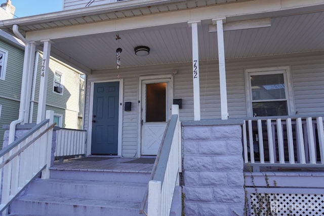 property entrance featuring covered porch and a chimney