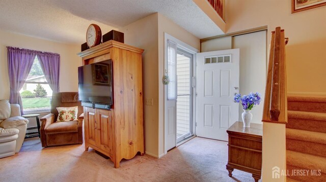 437 Belford Rd Unit B, Monroe, NJ 08831 - entryway featuring light carpet, stairway, and a textured ceiling