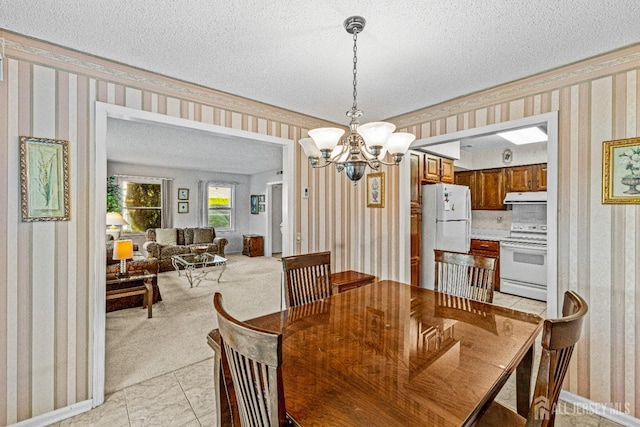 carpeted dining space featuring ornamental molding, an inviting chandelier, and a textured ceiling