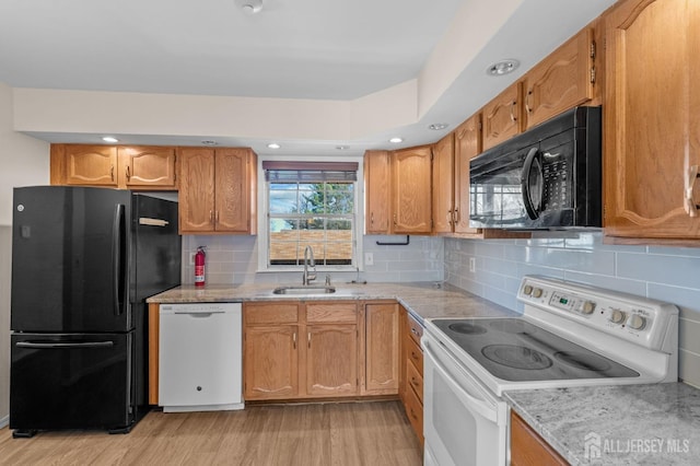 126 Concordia Cir Unit F, Monroe, NJ 08831 - kitchen featuring a sink, brown cabinetry, tasteful backsplash, black appliances, and light wood-style flooring