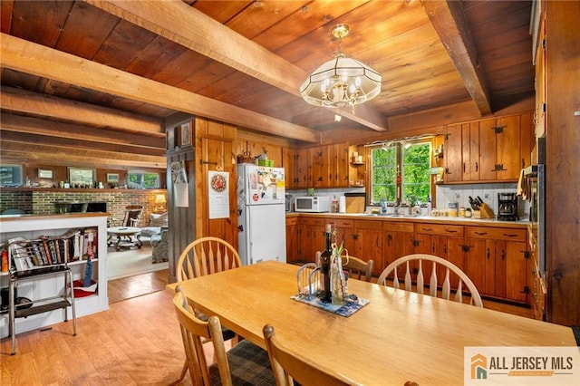 552 Parkview Ave, North Plainfield, NJ 07063 - dining area with wooden ceiling with exposed beams, light wood-type flooring, a chandelier, a fireplace, and wood walls
