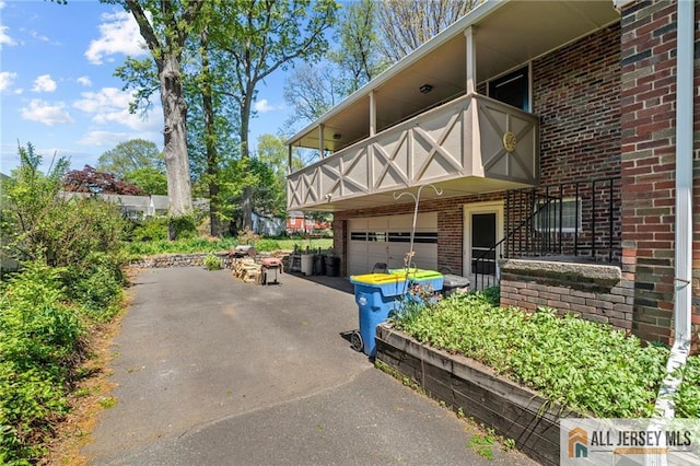 552 Parkview Ave, North Plainfield, NJ 07063 - view of side of home featuring a balcony, a garage, driveway, and brick siding
