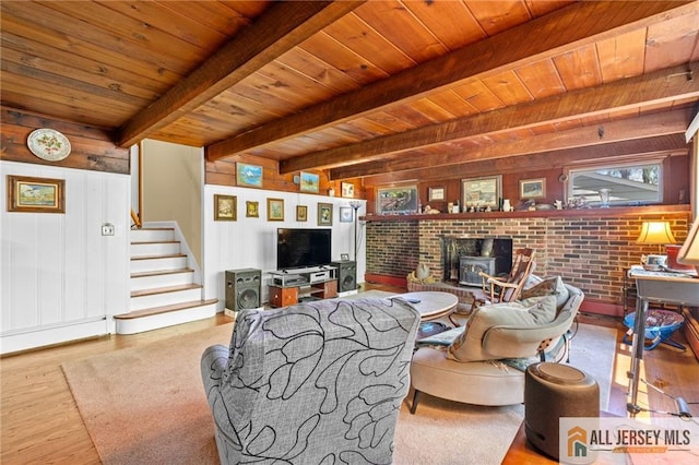 552 Parkview Ave, North Plainfield, NJ 07063 - living area with wooden ceiling with exposed beams, wood finished floors, a wood stove, stairway, and wood walls