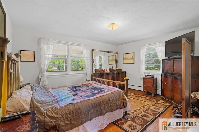 552 Parkview Ave, North Plainfield, NJ 07063 - bedroom featuring wood finished floors, baseboard heating, and a baseboard heating unit