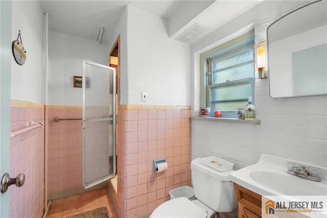 552 Parkview Ave, North Plainfield, NJ 07063 - bathroom with tile walls, a stall shower, tile patterned flooring, toilet, and vanity