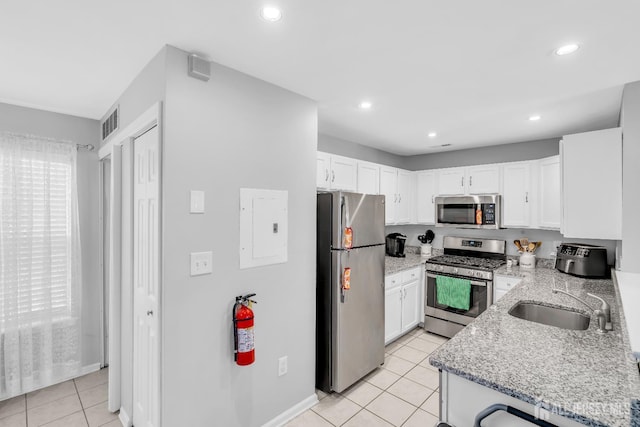 2207 Timber Ridge Ct, Sayreville, NJ 08859 - kitchen with appliances with stainless steel finishes, white cabinetry, light tile patterned flooring, light stone counters, and recessed lighting