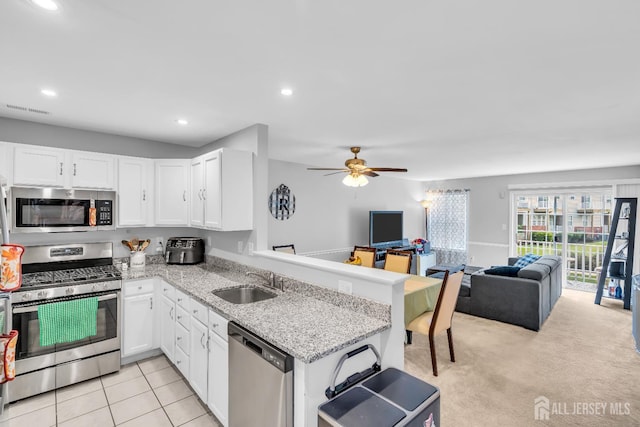 2207 Timber Ridge Ct, Sayreville, NJ 08859 - kitchen with appliances with stainless steel finishes, open floor plan, white cabinets, ceiling fan, and light stone countertops