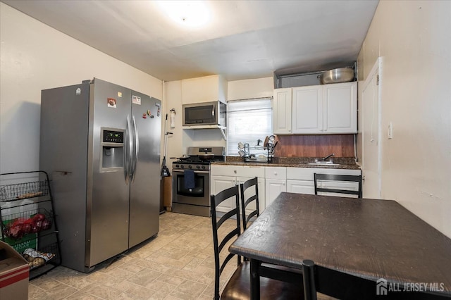 719 Catherine St, Perth Amboy, NJ 08861 - kitchen featuring stainless steel appliances, dark countertops, and white cabinetry