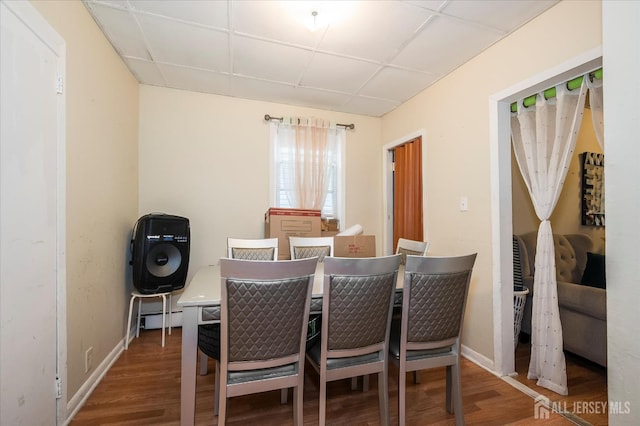 719 Catherine St, Perth Amboy, NJ 08861 - dining room with wood finished floors, a baseboard heating unit, baseboards, and a paneled ceiling