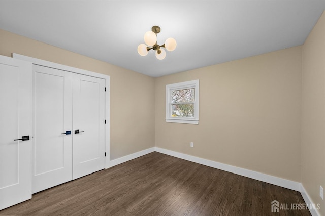 344 W Point Ave W, Franklin Twsp, NJ 08873 - unfurnished bedroom with baseboards, a notable chandelier, wood finished floors, and a closet