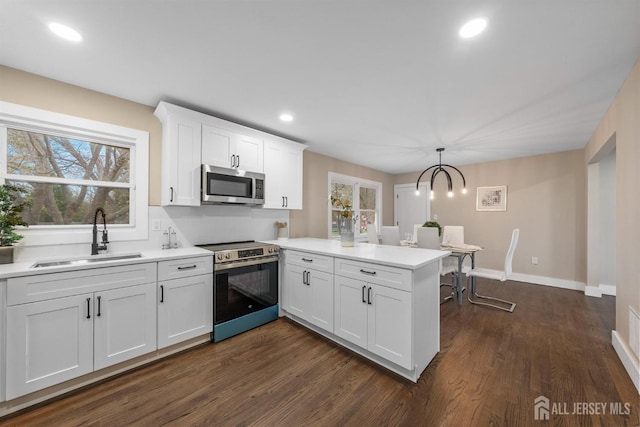 344 W Point Ave W, Franklin Twsp, NJ 08873 - kitchen with plenty of natural light, appliances with stainless steel finishes, a sink, white cabinets, and a peninsula