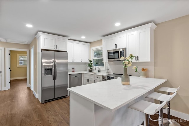 344 W Point Ave W, Franklin Twsp, NJ 08873 - kitchen featuring a peninsula, a sink, appliances with stainless steel finishes, and white cabinetry