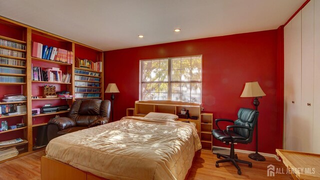 bedroom with light wood-type flooring and a closet