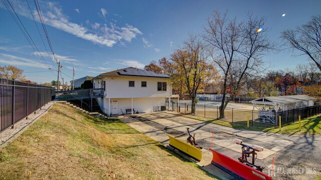 back of property featuring a lawn and solar panels