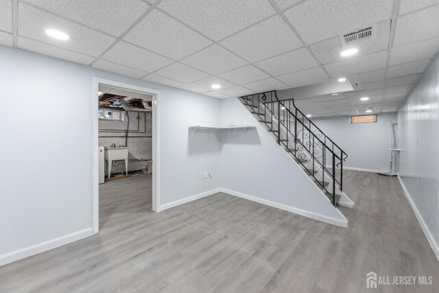 basement with hardwood / wood-style flooring and sink