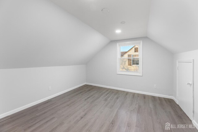 bonus room featuring light hardwood / wood-style floors and vaulted ceiling