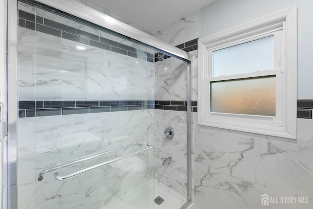 full bathroom featuring a marble finish shower