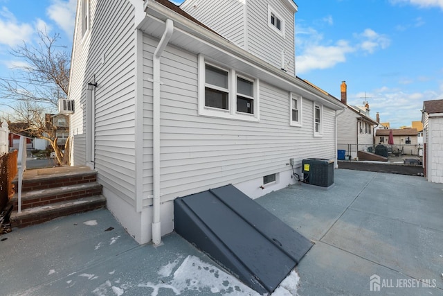 view of side of property featuring central air condition unit and a patio area