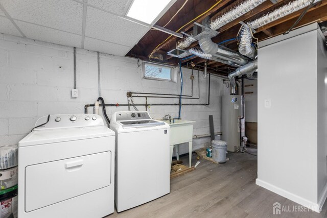 laundry area featuring washing machine and clothes dryer, sink, and water heater