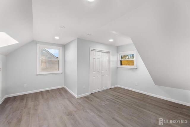 additional living space featuring lofted ceiling and hardwood / wood-style flooring