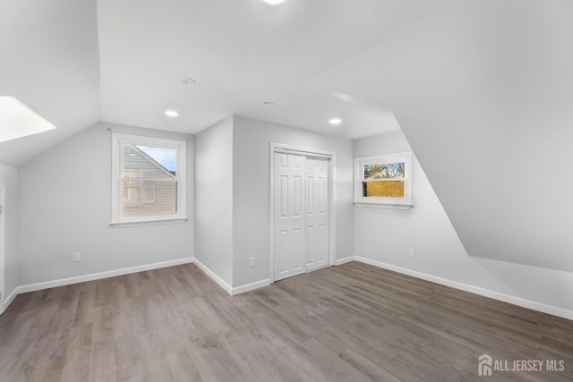 additional living space featuring recessed lighting, baseboards, wood finished floors, and vaulted ceiling