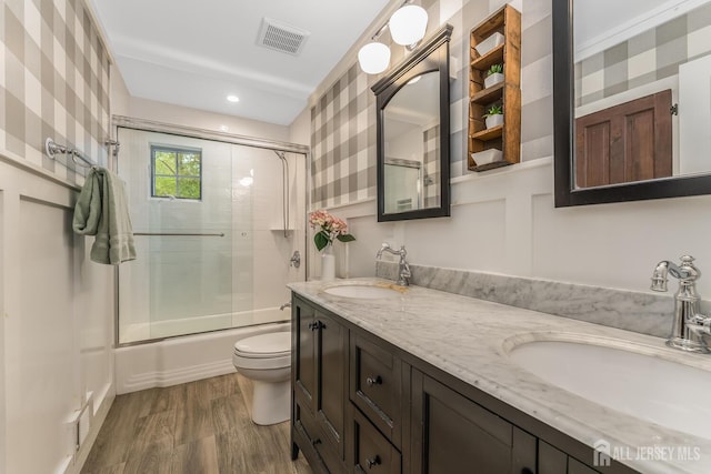 14 Bonnie Brook Ter, Middlesex, NJ 08846 - full bath featuring toilet, enclosed tub / shower combo, double vanity, wallpapered walls, and wood finished floors