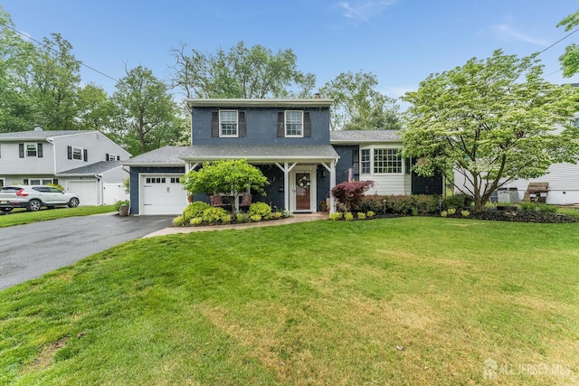 tri-level home with asphalt driveway, a garage, and a front lawn