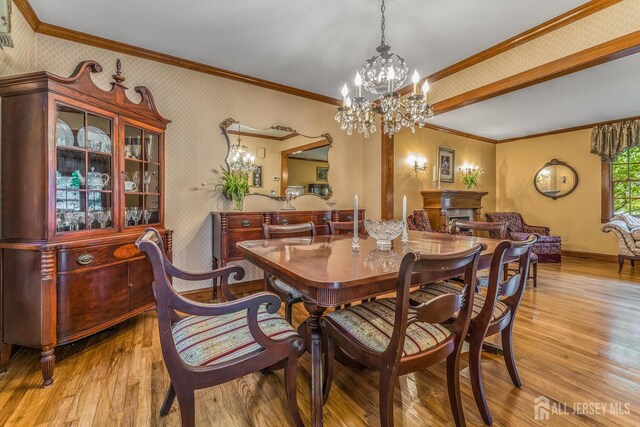 14 Bonnie Brook Ter, Middlesex, NJ 08846 - dining room featuring a chandelier, hardwood / wood-style floors, wallpapered walls, crown molding, and baseboards