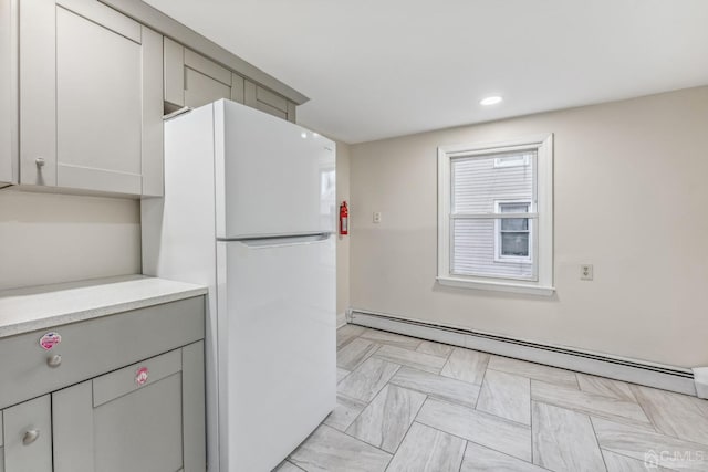 kitchen featuring recessed lighting, light countertops, freestanding refrigerator, and a baseboard radiator