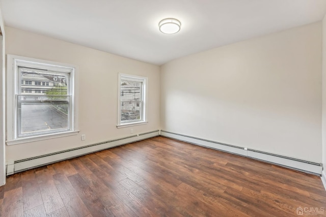 spare room with baseboard heating and hardwood / wood-style floors