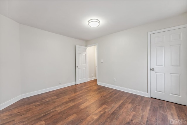 unfurnished room featuring baseboards and wood finished floors