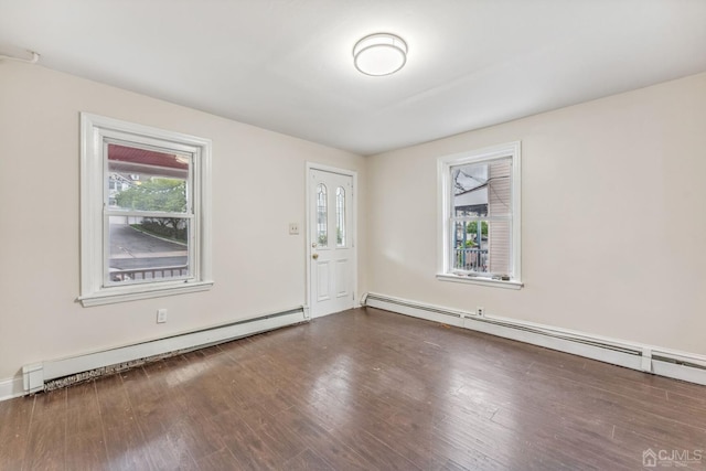 empty room with wood finished floors and a baseboard radiator