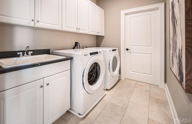 washroom with cabinets, washer and dryer, sink, and light tile patterned floors