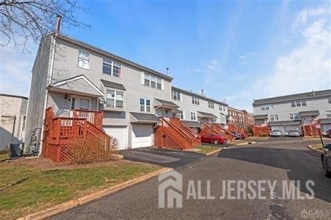 124 Lawrence St, New Brunswick, NJ 08901 - view of front facade featuring a residential view, driveway, a garage, and stairway
