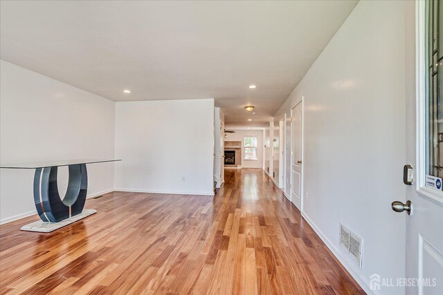 230 S 10th Ave S, Highland Park, NJ 08904 - unfurnished living room featuring a fireplace with raised hearth, light wood-style floors, and recessed lighting