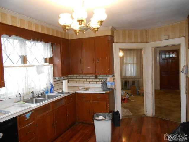 kitchen featuring sink, radiator, dark wood-type flooring, and an inviting chandelier