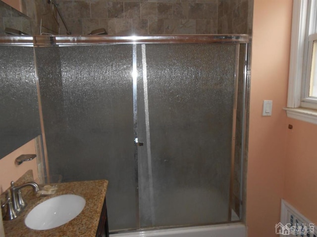 bathroom featuring walk in shower and vanity