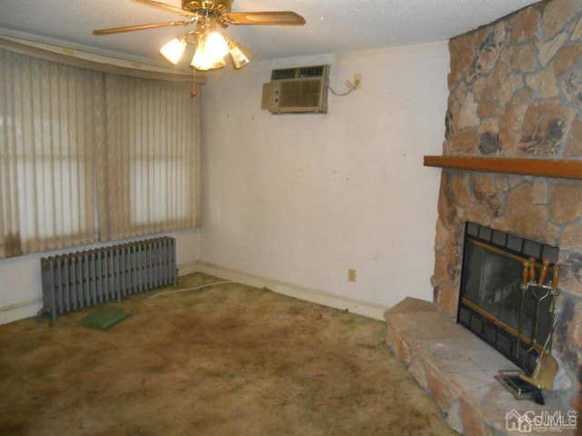 unfurnished living room with radiator heating unit, carpet flooring, a textured ceiling, a fireplace, and a wall unit AC