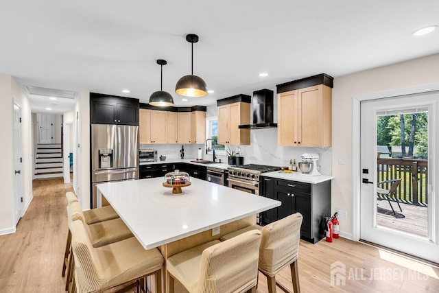 24 Bentley Rd, Monroe, NJ 08831 - kitchen with stainless steel appliances, wall chimney exhaust hood, a sink, light brown cabinetry, and a breakfast bar