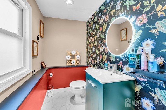 24 Bentley Rd, Monroe, NJ 08831 - half bathroom with wallpapered walls, marble look tiles, toilet, vanity, and baseboards