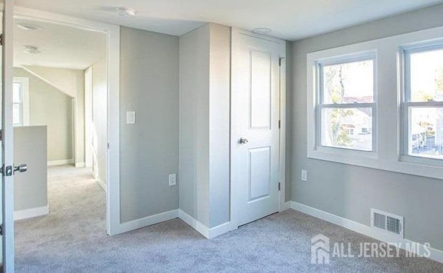 unfurnished bedroom featuring light carpet