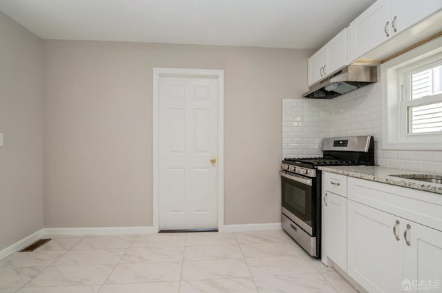 kitchen featuring white cabinets, marble finish floor, stainless steel range with gas stovetop, and under cabinet range hood