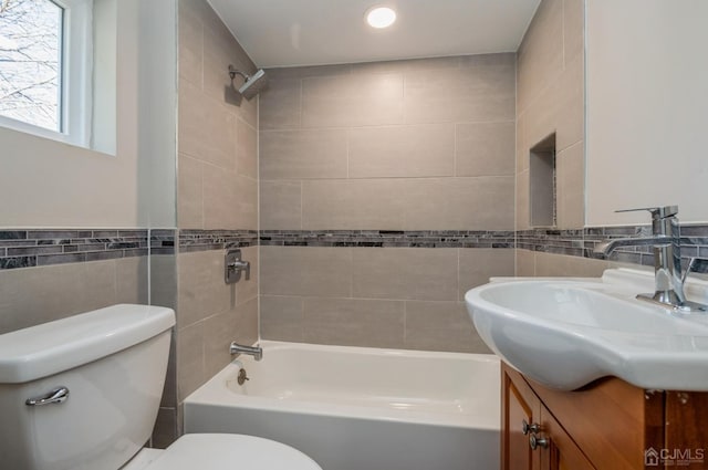 full bath featuring shower / bath combination, tile walls, toilet, and vanity