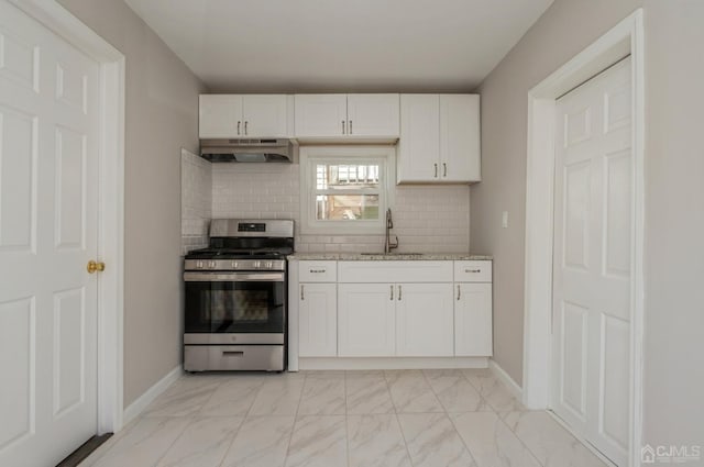 kitchen featuring marble finish floor, white cabinetry, a sink, gas range, and under cabinet range hood