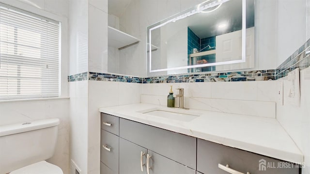 full bathroom featuring decorative backsplash, vanity, toilet, and tile walls