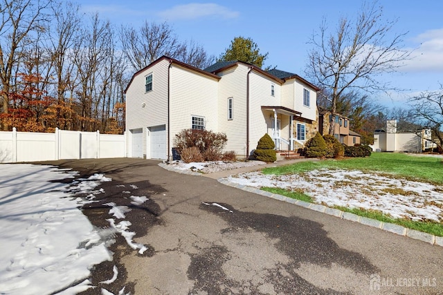 exterior space with an attached garage, driveway, and fence