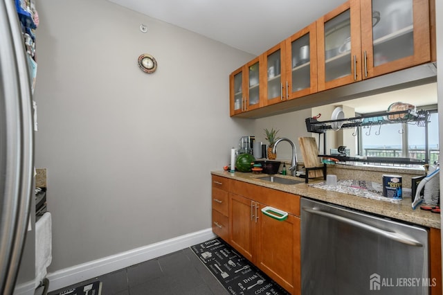 1 Spring St Unit 1206, New Brunswick, NJ 08901 - kitchen with dishwasher, brown cabinetry, glass insert cabinets, dark tile patterned flooring, and freestanding refrigerator